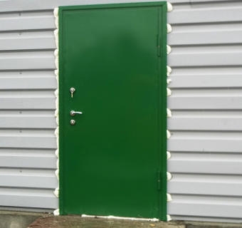 Зеленая техническая дверь в дачном доме